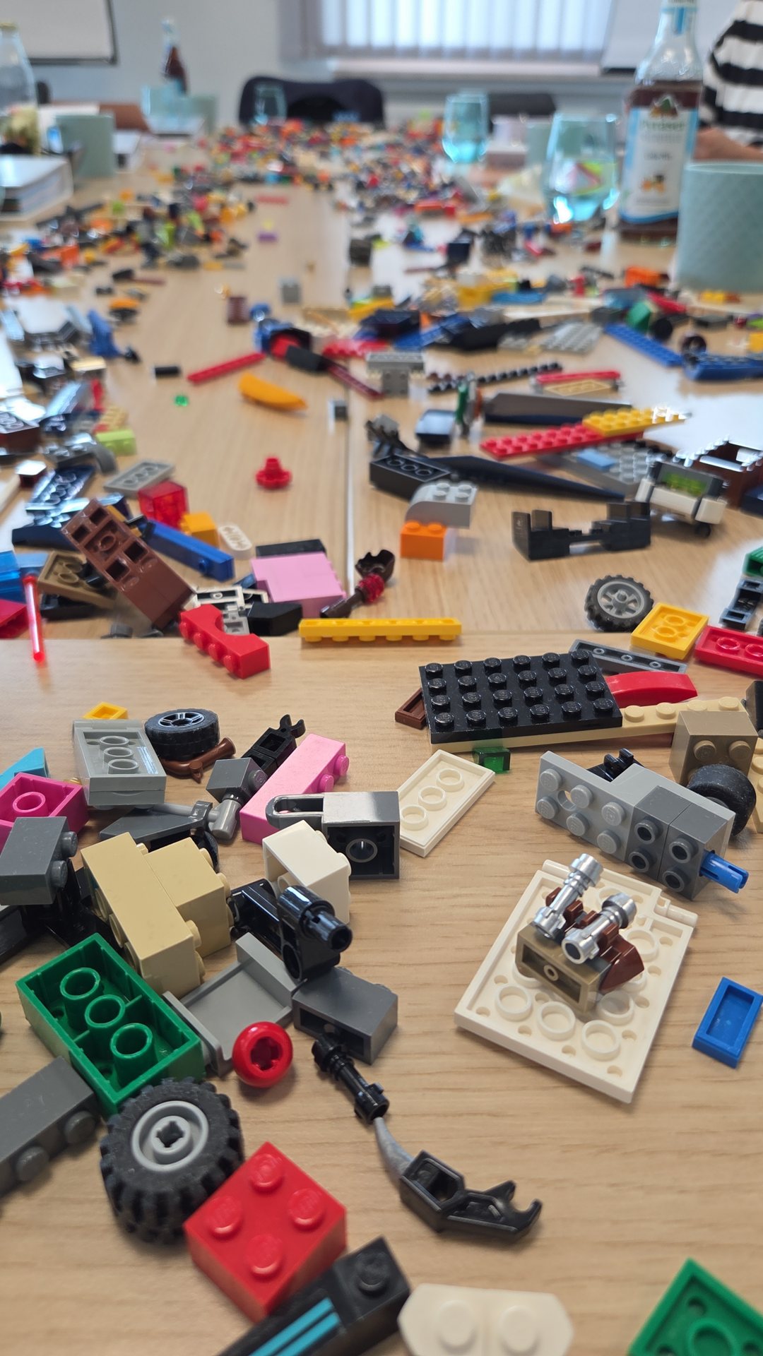 Langer Besprechungstisch voller LEGO-Steine, Räder und Platten für einen Workshop
